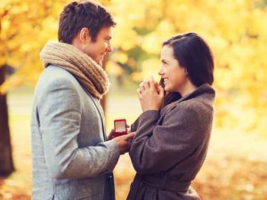 smiling proposing couple with red gift box in autumn park